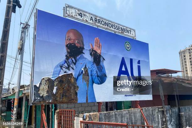 General view of a defaced campaign billboard of ousted Gabon President Ali Bongo Ondimba in Libreville on August 31, 2023. People in the central...
