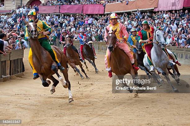 Horses of contrade Pantera , Valdimontone , Bruco , Civetta , Drago and Tartuca approaching at the dangerous corner of San Martino in "Piazza del...