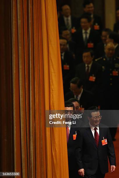Incoming President Xi Jinping follows behind the outgoing Chinese President Hu Jintao to attend the fourth plenary meeting of the National People's...