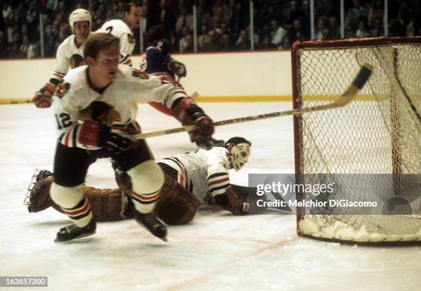 Goalie Tony Esposito of the Chicago Blackhawks made the save as teammate Pat Stapleton goes for the puck during an NHL game against the New York...