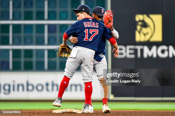 Luis Urias highs Pablo Reyes of the Boston Red Sox after defeating the Houston Astros at Minute Maid Park on August 24, 2023 in Houston, Texas.