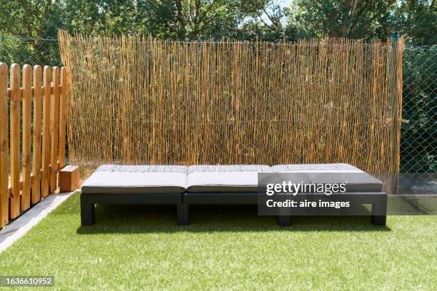 front view of backyard with empty lounge chair in front of wooden fence - whitewashed fence stock pictures, royalty-free photos & images