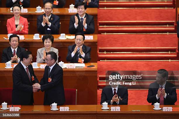 Former NPC Chairman Wu Bangguo shakes hands with newly-elected NPC Chairman Zhang Dejiang as China's newly-elected President Xi Jinping and former...