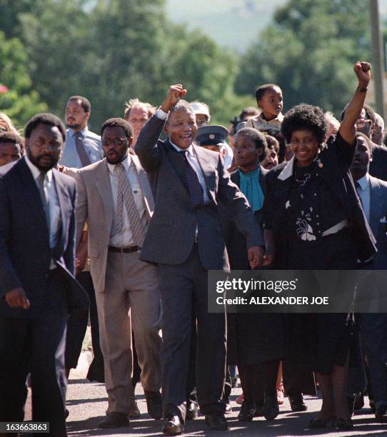 Picture taken on February 11, 1990 shows Nelson Mandela and his then-wife anti-apartheid campaigner Winnie raising their fists and saluting cheering...