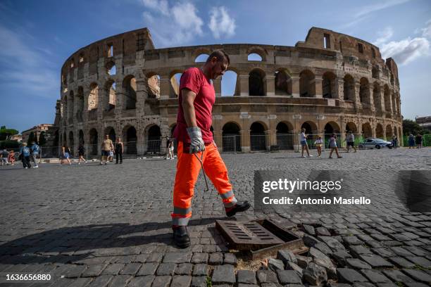 An AMA pest control team member prepares to set a rat poison bait in a manhole around the Colosseum to tackle an infestation of rats, on August 31,...