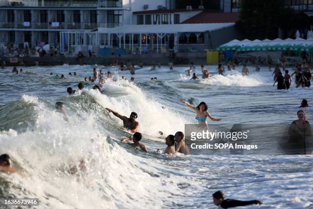 People are seen bathing in stormy waters at Lanzheron Beach During the ongoing military conflict with Russia, people bathe in the stormy sea,...