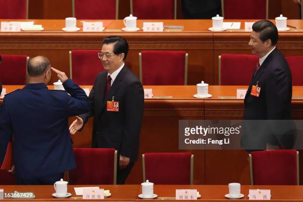 Former President Hu Jintao shakes hands with Chinese vice chairman of the Central Military Commission Xu Qiliang as newly-elected Chinese President...