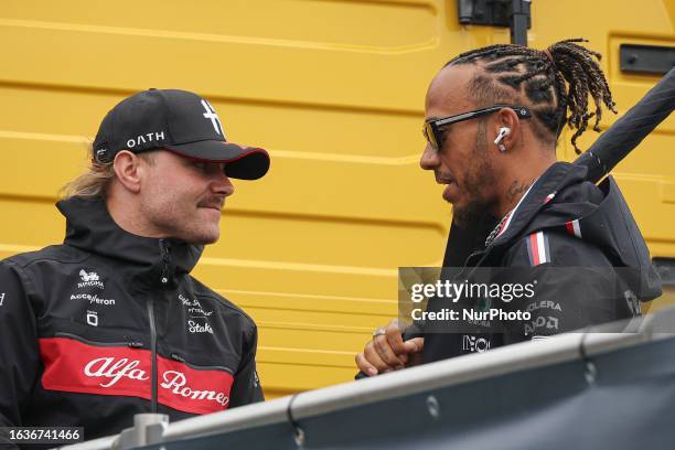 Lewis Hamilton of Great Britain as seen talking with Valtteri Bottas of Finland. A challenging race followed after a heavy downpour rain led to red...