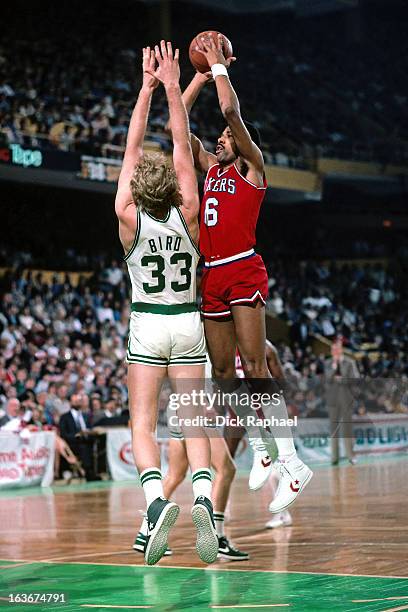 Julius Erving of the Philadelphia 76ers shoots against Larry Bird of the Boston Celtics during a game played circa 1984 at the Boston Garden in...