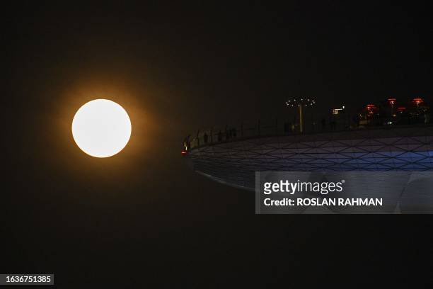 Super blue moon rises behind Marina Bay Sands observation deck in Singapore on August 31, 2023.
