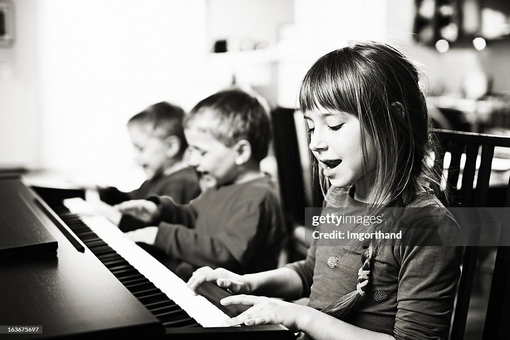 Children having fun playing the piano and singing