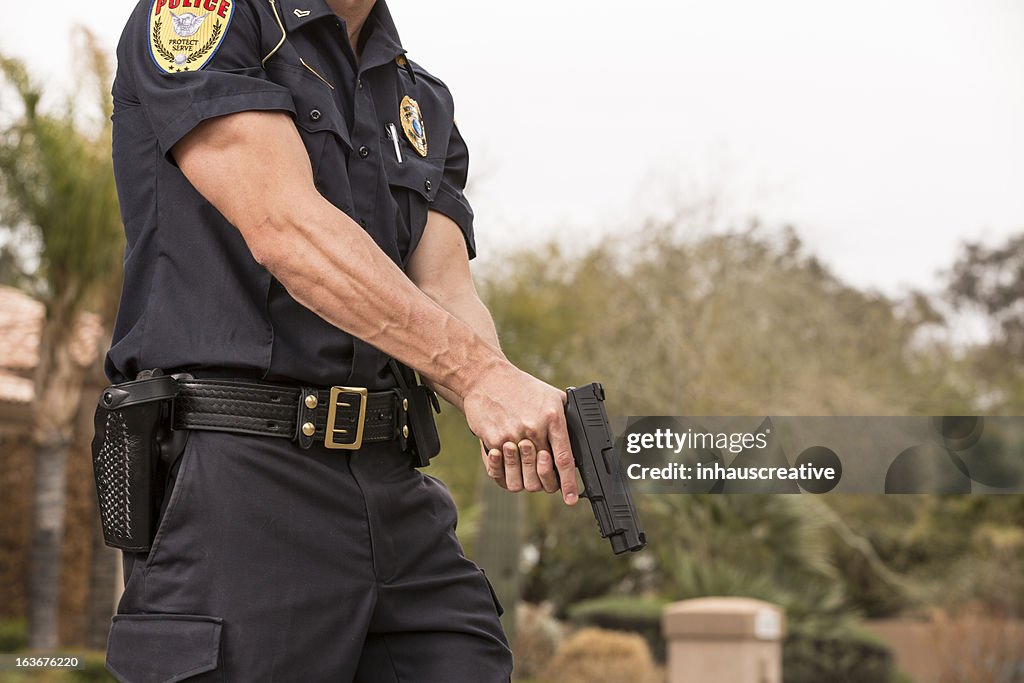 Policeman with his gun drawn