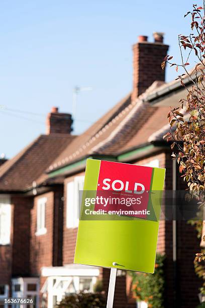 inglés casa suburbana'sold'con una señal. - sold palabra en inglés fotografías e imágenes de stock