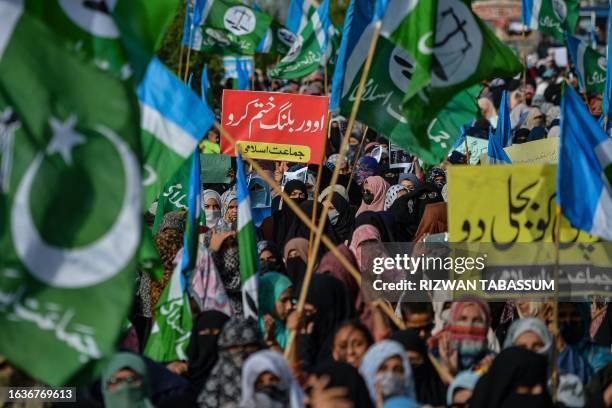 Women activists of Pakistani right wing religious party Jamat-e-Islami shout slogans and hold placards reading "Eliminate overbilling" during a...