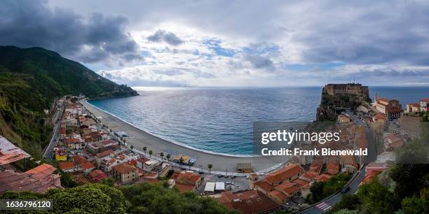 Panoramic view of the Ruffo Castle on a rock cliff and overlooking the Mediterranean sea, the beach and the houses of the small town.