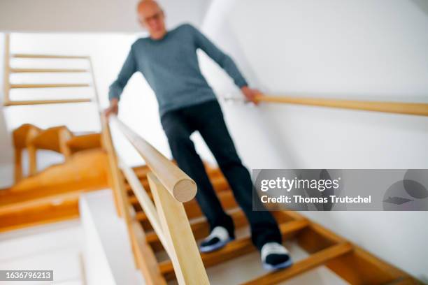 Symbolic photo on the topic of accident risk in the household. An old man is walking down a steep flight of stairs on August 31, 2023 in Berlin,...