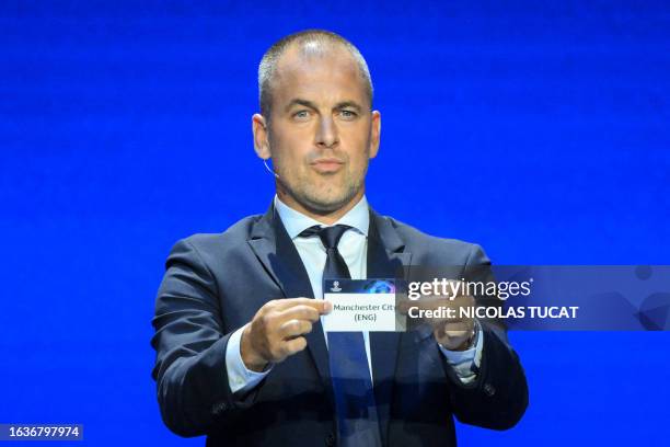 English former football player Joe Cole shows the paper slip of Manchester City during the draw for the 2023/2024 UEFA Champions League football...