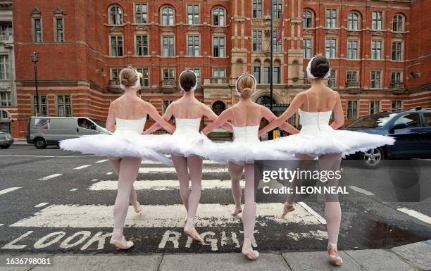 Dancers from the English National Ballet walk across a pedestrian crossing during a photocall to promote the opening of 'Swan Lake in-the-round',...