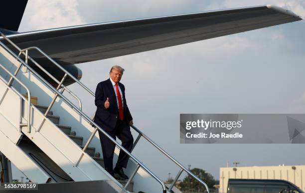 Former U.S. President Donald Trump gives a thumbs up as he arrives at Atlanta Hartsfield-Jackson International Airport on August 24, 2023 in Atlanta,...