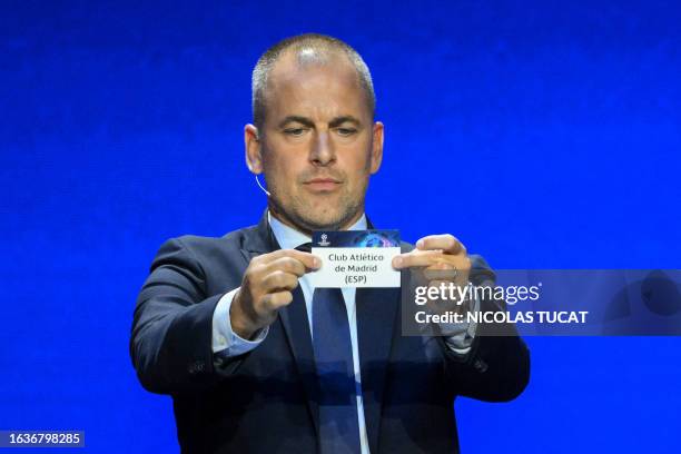 English former football player Joe Cole shows the paper slip of Atletico de Madrid during the draw for the 2023/2024 UEFA Champions League football...