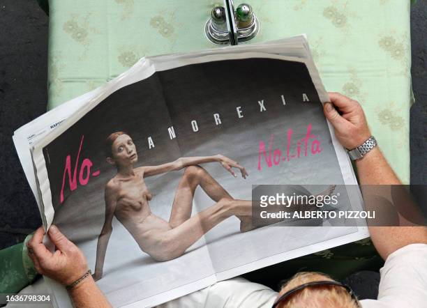Man reads an Italian newspaper in Rome 24 September 2007, showing the new fashion brand Nolita advertising campaign against anorexia, realised by...