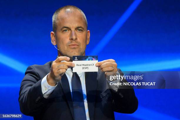 English former football player Joe Cole shows the paper slip of Real Madrid during the draw for the 2023/2024 UEFA Champions League football...