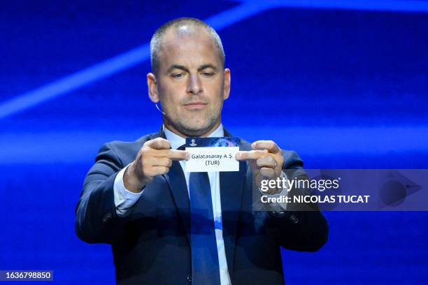 English former football player Joe Cole shows the paper slip of Galatasaray during the draw for the 2023/2024 UEFA Champions League football...