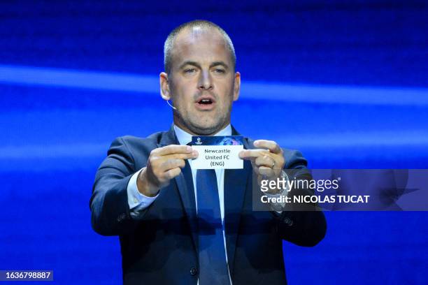 English former football player Joe Cole shows the paper slip of Newcastle United FC during the draw for the 2023/2024 UEFA Champions League football...