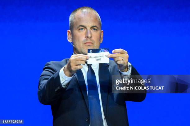 English former football player Joe Cole shows the paper slip of Royal Antwerp FC during the draw for the 2023/2024 UEFA Champions League football...