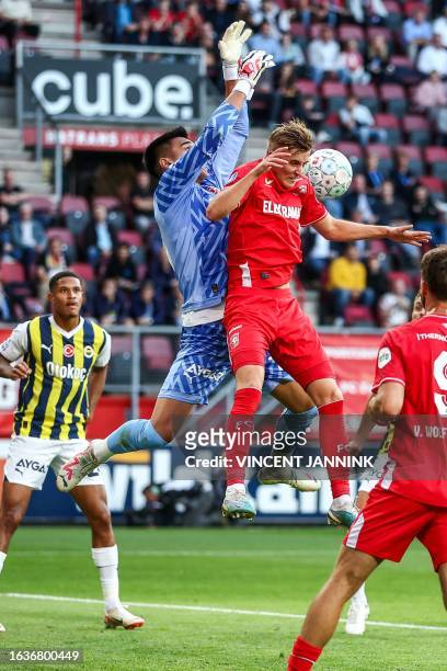 Fenerbahce's Turkish goalkeeper Irfan Can Egribayat fights for the ball with FC Twente's Dutch midfielder Max Bruns during the UEFA Conference League...