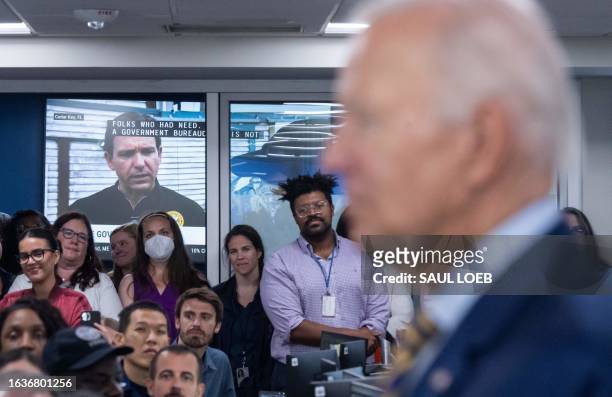 Television displays a video of Florida Governor Ron DeSantis as US President Joe Biden speaks the headquarters of the Federal Emergency Management...