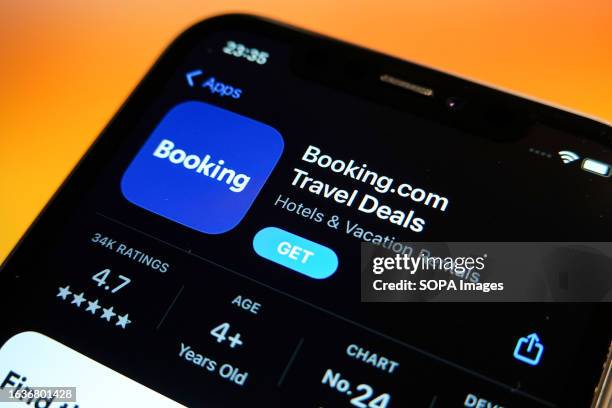 In this photo illustration, the Booking.com logo is displayed in the Apple App Store on an iPhone.