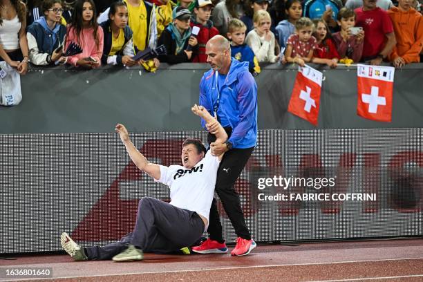 Stadium invader is restrained by an official during the Diamond League athletics meeting at Stadion Letzigrund stadium in Zurich on August 31, 2023.