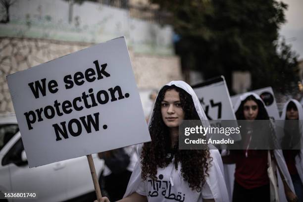 People hold banners during staging a protest march with coffins, against the government's indifference on the increase in crime rates amongst...