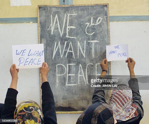 Students of Zarghoona girls' high school hold peace signs during the visit of United Nations Secretary General Kofi Annan in Kabul 25 January 2002....