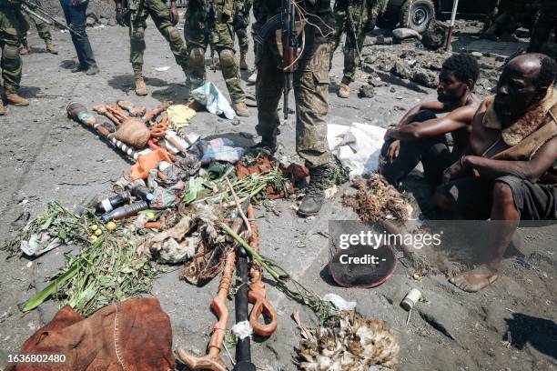 People arrested during a military operation to prevent a planned demonstration against the United Nations by a religious sect, sit in front of their...