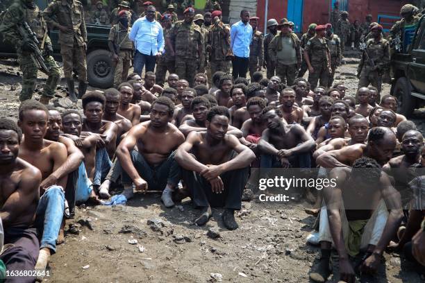 People arrested during a military operation to prevent a planned demonstration against the United Nations by a religious sect, sit on the ground and...