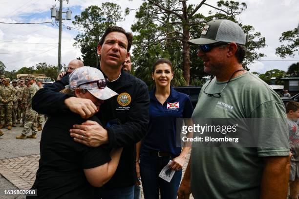 Ron DeSantis, governor of Florida and 2024 Republican presidential candidate, center left, embraces a resident during a visit after Hurricane Idalia...