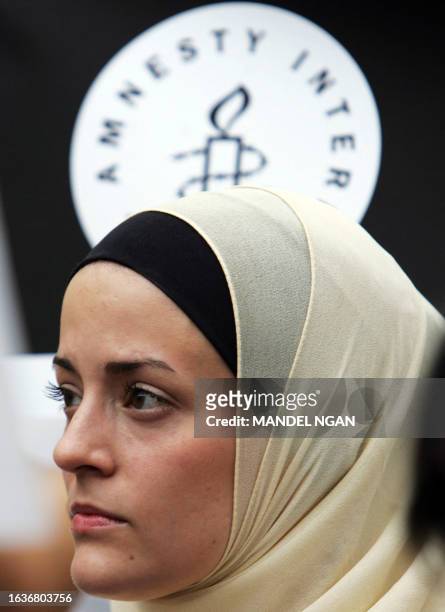 George Washington University student Mariam Howe, who converted from Catholicism to Islam, holds a candle during a vigil organized by Amnesty...