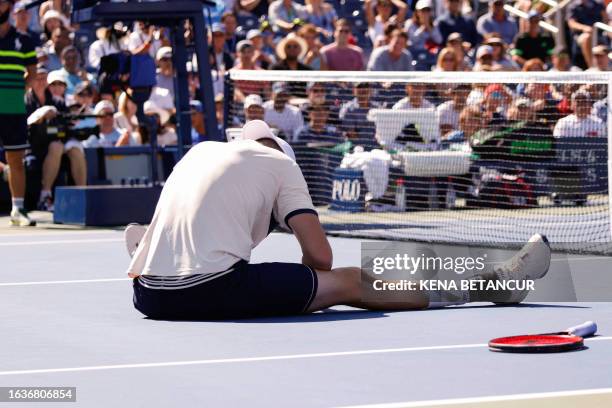 John Isner of the United States falls in a final career match loss against Michael Mmoh during their Men's Singles Second Round match at the 2023 US...