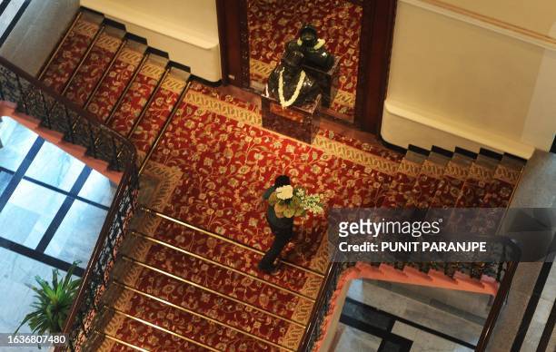 Hotel employee carries flowers in the newly-restored heritage wing of Mumbai's landmark Taj Mahal Palace and Tower hotel is seen on August 11, 2010...