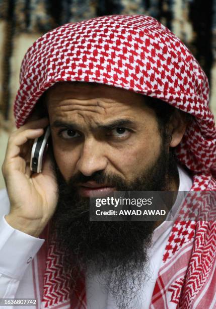 Released Jordanian Guantanamo inmate Osama Abu Kabir talks on a mobile phone as he waits to be greeted by his family in the town of Rusief, northeast...