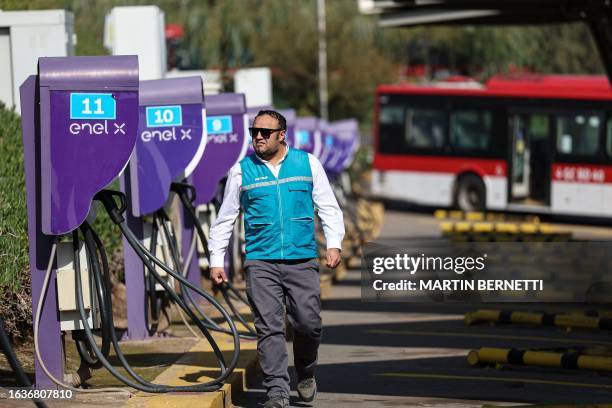 Worker of the Red Bus transport network walks at an electric charging center of the fleet of electric buses in Santiago on August 1, 2023. Santiago,...