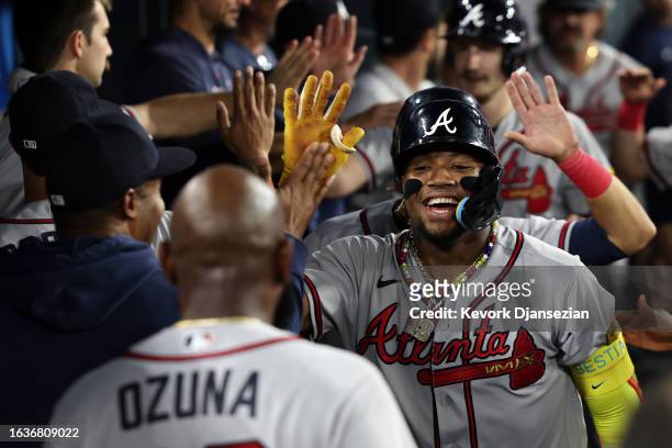 Ronald Acuna Jr. #13 of the Atlanta Braves celebrates his grand slam home run in the dugout with teammates during the second inning at Dodger Stadium...