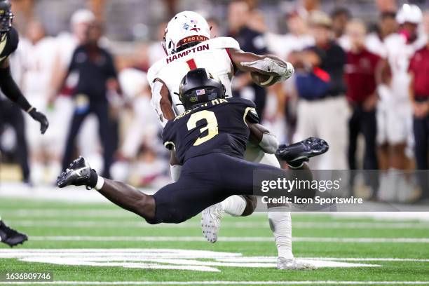 Malik Mustapha of the Wake Forest Demon Deacons dives to tackle Jalen Hampton of the Elon Phoenix as he runs the ball during a football game at...