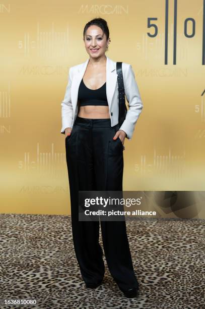August 2023, Baden-Württemberg, Bodelshausen: Youtuber Anna Nooshin stands on the red carpet at Marc Cain headquarters during the anniversary fashion...