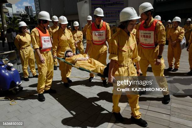 Employees of the Mori Building Company conduct emergency transport training as part of the company's earthquake disaster drill at Tokyo's Roppongi...