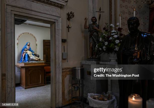 An interior scene of Holy Rosary Church with the statue of the La Pietà, left, and a basket of bread to offer parishioners during an Italian Mass and...