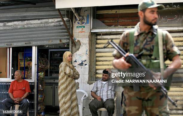 An Islamic militant of a joint force of various factions of the Palestine Liberation Organization , pro-Syrian groups and Islamist movements, secures...