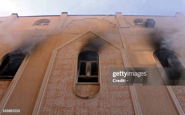 Smoke billows from the windows of an Egyptian Coptic church in the eastern Libyan city of Benghazi after gunmen attacked the religious site and...